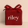 Red gift box with a bow and 'riley' text on a beige background