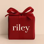 Red gift box with a bow and 'riley' text on a beige background